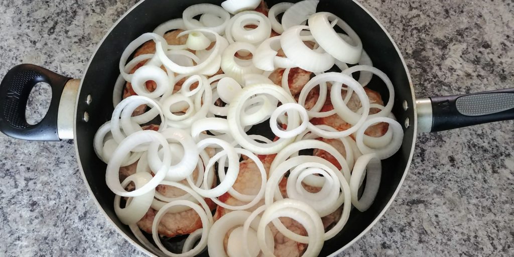 Saucy Pork Chop Dinner Onions and Chops in Pan