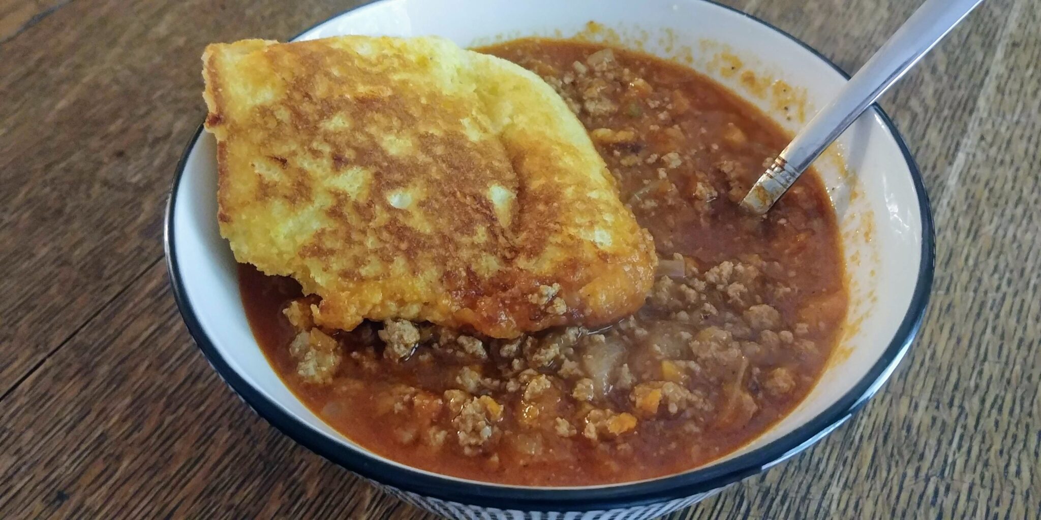 https://thekitchenwench.com/wp-content/uploads/2023/01/Turkey-Chili-complete-in-bowl-with-corn-muffin-topper-scaled.jpg